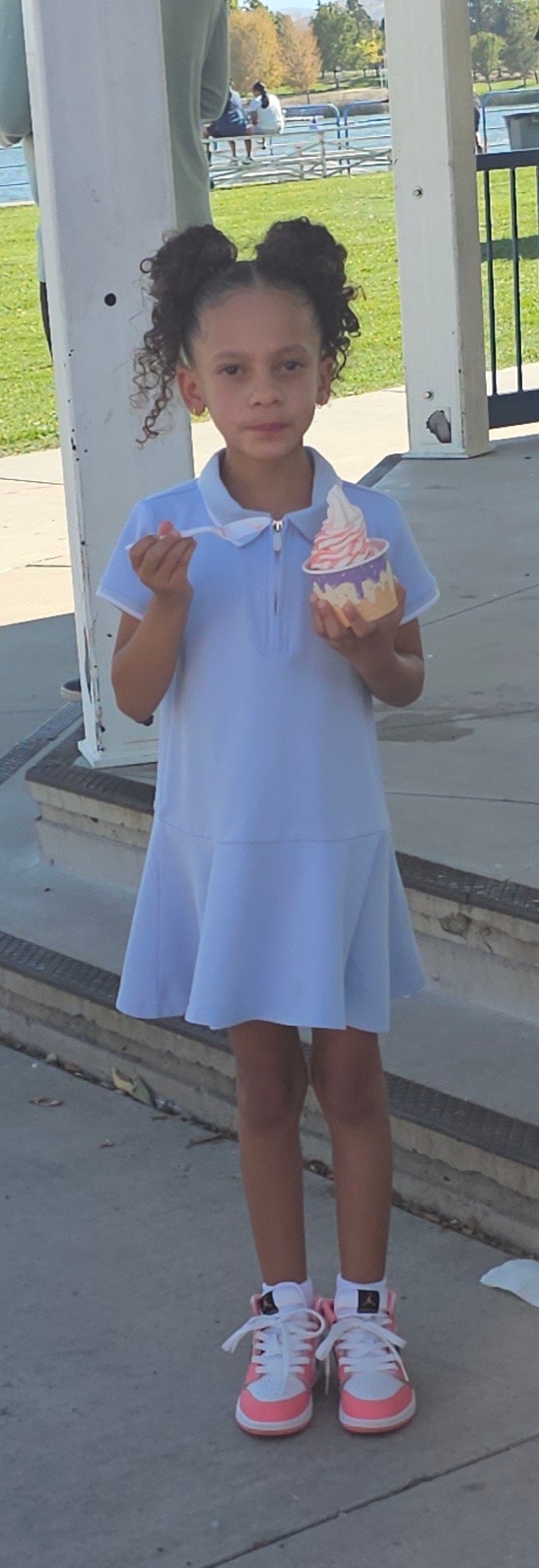 Young girl enjoying pink and white High Sierra soft serve by the waterfront